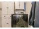 View of Samsung front load dryer in laundry room with white storage cabinet and clothes hanging nearby at 21354 Austin Ave, Port Charlotte, FL 33952