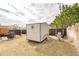 View of backyard shed, shade, and grilling area on a lot with pebble and grass at 21354 Austin Ave, Port Charlotte, FL 33952