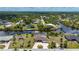 Aerial view showcasing a waterfront home with a dock, surrounded by lush greenery and other residences at 4122 Library St, Port Charlotte, FL 33948