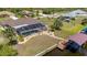 Aerial view showcases the screen enclosed pool, lush lawn, and boat dock on the canal at 4122 Library St, Port Charlotte, FL 33948