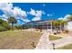 Wide backyard featuring large screened-in lanai, meticulous landscaping and brick walkway at 4122 Library St, Port Charlotte, FL 33948