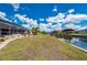 Large backyard with green grass connects the house with screened pool to the canal and dock at 4122 Library St, Port Charlotte, FL 33948