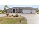Charming exterior showcasing meticulous landscaping, a three-car garage, and inviting entrance at 4122 Library St, Port Charlotte, FL 33948