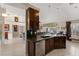 Open concept kitchen features dark wood cabinets and seamless access to the living room at 4122 Library St, Port Charlotte, FL 33948