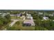 Aerial view of a home with a screened-in pool, lush greenery, and neighboring homes in the background at 5435 Montego Ln, Port Charlotte, FL 33981