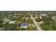 Aerial view of a charming home with a screened-in pool surrounded by mature trees in a quiet neighborhood at 5435 Montego Ln, Port Charlotte, FL 33981