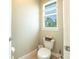 Cozy powder room with a toilet next to the window, complemented with neutral decor at 5435 Montego Ln, Port Charlotte, FL 33981