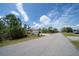 Street view of a home featuring a three-car garage, well-maintained lawn, and clear blue skies at 5435 Montego Ln, Port Charlotte, FL 33981