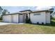 A modern single-Gathering home featuring a two-car garage, a minimalist landscape, and a well-maintained lawn at 5435 Montego Ln, Port Charlotte, FL 33981