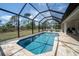 Sparkling pool surrounded by a screened enclosure and a paved patio, offering backyard views at 5435 Montego Ln, Port Charlotte, FL 33981