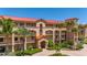 Beautiful condo building with red roof, balconies and lush tropical landscaping at 89 Vivante Blvd # 205, Punta Gorda, FL 33950