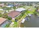 An aerial view of an idyllic residential neighborhood featuring waterfront homes with private docks, screened pools, and lush landscapes at 3663 Whippoorwill Blvd, Punta Gorda, FL 33950