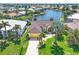 An aerial view of a waterfront home featuring lush landscaping, a tile roof, and canal access at 3663 Whippoorwill Blvd, Punta Gorda, FL 33950