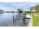 Waterfront property with boat dock featuring a boat lift, and water access, surrounded by lush landscaping and swaying palm trees at 3663 Whippoorwill Blvd, Punta Gorda, FL 33950