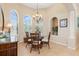 Bright dining room boasts elegant chandelier, arched windows with shutters, and stylish rattan furniture at 3663 Whippoorwill Blvd, Punta Gorda, FL 33950