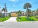 Beautiful single-story home featuring a lush front lawn, arched entry, and two-car garage surrounded by majestic palm trees at 3663 Whippoorwill Blvd, Punta Gorda, FL 33950