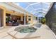 Relaxing enclosed lanai with hot tub and lush tropical landscaping, creating a private outdoor oasis at 3663 Whippoorwill Blvd, Punta Gorda, FL 33950