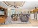 Inviting living room featuring leather sofas, a decorative rug, and a tray ceiling with a fan at 3663 Whippoorwill Blvd, Punta Gorda, FL 33950