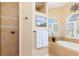Relaxing soaking tub and shower with tile surround in the well-lit main bathroom at 3663 Whippoorwill Blvd, Punta Gorda, FL 33950
