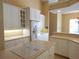 Well-equipped kitchen features white cabinetry, updated appliances, a cooktop island, and ample counter space at 3932 Madrid Ct, Punta Gorda, FL 33950