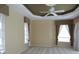 Serene main bedroom with tray ceiling, ceiling fan, plush carpeting, and natural light from the windows at 3932 Madrid Ct, Punta Gorda, FL 33950