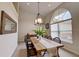 Dining room showcases a modern chandelier, large arched window, and a wooden table set for six, perfect for gatherings at 4046 Lubec Ave, North Port, FL 34287