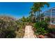 Lush backyard landscape and brick path to the canal, with a screened lanai and outdoor seating at 805 Brenda Ct, Punta Gorda, FL 33950