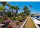 Landscaped backyard with vibrant flowers, a swing, and a boat dock along the waterfront at 805 Brenda Ct, Punta Gorda, FL 33950