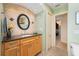 Bathroom features an oval mirror over a wooden vanity with granite countertop at 805 Brenda Ct, Punta Gorda, FL 33950