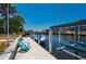 Waterfront dock featuring a boat lift, a boat, and a relaxing chair overlooking the serene canal at 805 Brenda Ct, Punta Gorda, FL 33950