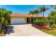 Inviting home showcasing a well-manicured yard, paver driveway, and an attached garage at 805 Brenda Ct, Punta Gorda, FL 33950