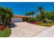 Charming home featuring a red tile roof, lush landscaping, and a brick driveway, exuding curb appeal and inviting warmth at 805 Brenda Ct, Punta Gorda, FL 33950