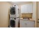 Laundry room features a stacked washer and dryer with white cabinets at 805 Brenda Ct, Punta Gorda, FL 33950
