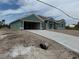 New construction home featuring a concrete driveway, a two-car garage, and neutral-colored exterior paint at 8599 Waldrep St, Port Charlotte, FL 33981