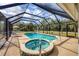 Inviting screened-in pool area with a spa, lounge chairs, and beautiful outdoor setting at 14057 Maxwell Ave, Port Charlotte, FL 33953