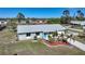 Charming single-story home with a bright blue front door, well-kept lawn, and tropical landscaping with young palm trees at 18086 Clanton Ave, Port Charlotte, FL 33948