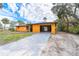 Charming home featuring an open carport, a long driveway and lush tropical landscaping at 201 Winson Ave, Englewood, FL 34223