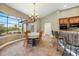 Dining area featuring tan walls, tile flooring, a chandelier, a window overlooking golf course, and bar seating at 3977 La Costa Island Ct, Punta Gorda, FL 33950
