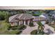 Stunning custom home features a paver driveway, barrel tile roof, and lush landscaping and pond views at 3977 La Costa Island Ct, Punta Gorda, FL 33950