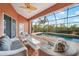 Screened lanai with comfortable wicker furniture and a view of the sparkling pool at 3977 La Costa Island Ct, Punta Gorda, FL 33950