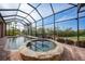 Enclosed pool and spa area with a covered lanai, brick pavers, and lush tropical landscaping at 3977 La Costa Island Ct, Punta Gorda, FL 33950