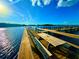 Scenic view of a wooden dock with a picnic table extending into the tranquil waters under a clear blue sky at 500 Woodstork Ln, Punta Gorda, FL 33982