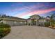 Stunning home with a spacious three-car garage and beautiful landscaping, set against a vibrant sunset sky at 500 Woodstork Ln, Punta Gorda, FL 33982