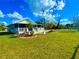 Charming home with a screened porch, manicured lawn, flagpole, and lush landscaping, perfect for outdoor living at 500 Woodstork Ln, Punta Gorda, FL 33982