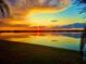 Breathtaking sunset reflecting on calm waters, framed by lush greenery and tropical foliage at 500 Woodstork Ln, Punta Gorda, FL 33982