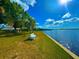 Picturesque waterfront with a bench, picnic area, lush trees, and serene water views under a bright, sunny sky at 500 Woodstork Ln, Punta Gorda, FL 33982
