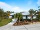 Charming single story home with a metal roof, a well manicured lawn, and mature landscaping at 700 N River Rd, Venice, FL 34293