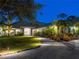Stunning home featuring lush landscaping, an inviting entrance, and exterior lighting at 700 N River Rd, Venice, FL 34293
