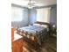 Comfortable bedroom with a wooden-framed bed, ceiling fan, and natural light from two windows at 1174 Victoria Ave, Port Charlotte, FL 33948
