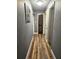 Hallway with wood-look flooring, neutral paint, and multiple doorways offering a modern look at 1174 Victoria Ave, Port Charlotte, FL 33948